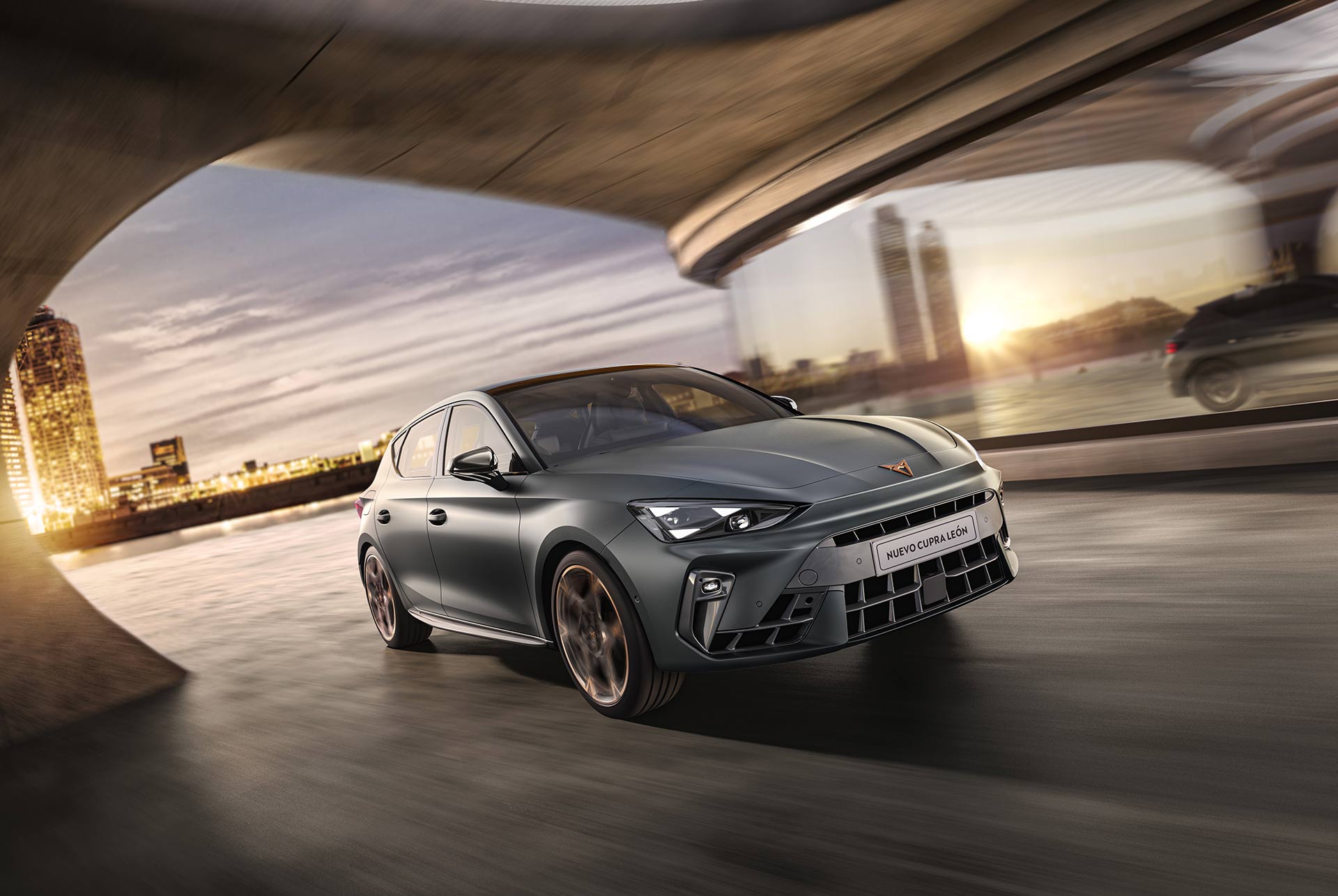 three quarter front view of a new grey cupra leon 2024 in motion, Barcelona cityscape in the background and reflection.